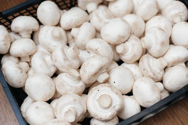 Ripe fresh mushrooms in a box in the warehouse after assembling a close-up.