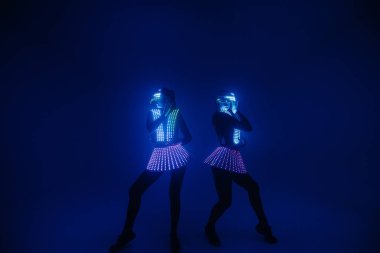 UV kostümlü iki seksi disko dansçısı. Partiler ve danslar.