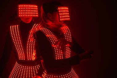 UV kostümlü iki seksi disko dansçısı. Partiler ve danslar.