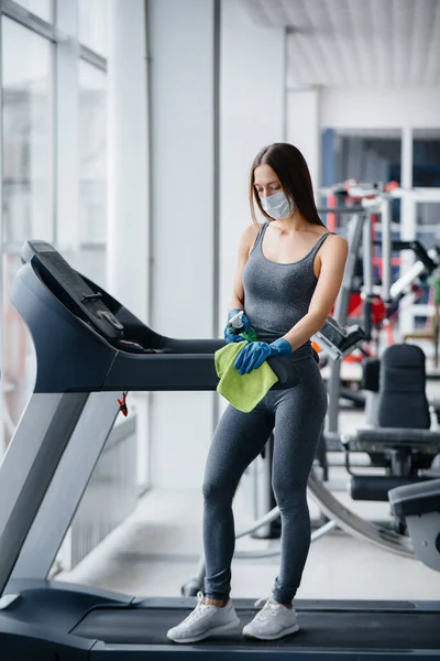 Het Meisje Met Het Masker Desinfecteert Fitnessapparatuur Tijdens Een Pandemie — Stockfoto