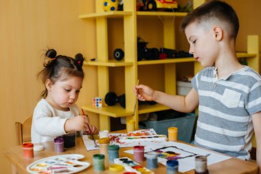 Bir erkek ve bir kız birlikte oynayıp resim yapıyorlar. Eğlence ve eğlence. Evde kal.