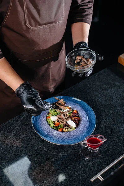 一位专业厨师在一家时尚的现代餐厅里准备了一份新鲜的蔬菜沙拉和多汁的小牛肉 在餐馆做饭 — 图库照片