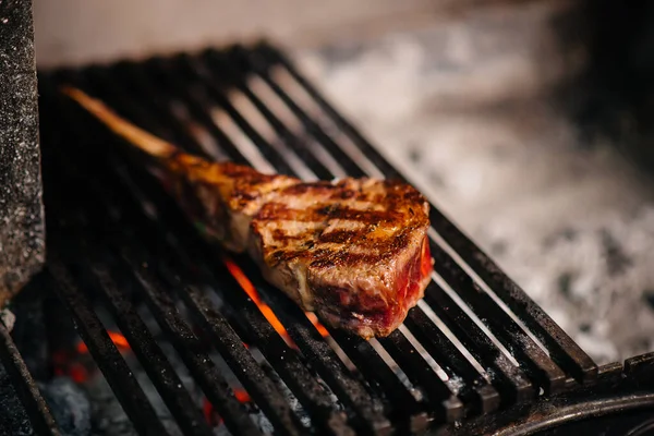 Juicy steak is grilled in a restaurant. Roasting meat in the fire on the grill.