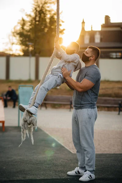 Padre Ayuda Hijo Trepar Una Cuerda Campo Deportes Con Máscaras — Foto de Stock