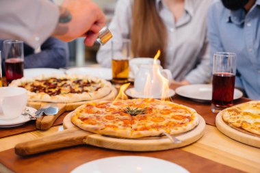Dostça bir akşam yemeği sırasında benzersiz sıcak pizza yakın planda..