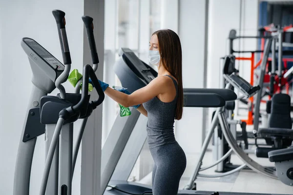 Het Meisje Met Het Masker Desinfecteert Fitnessapparatuur Tijdens Een Pandemie — Stockfoto