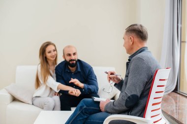 Genç, mutlu, evli bir çift terapi seansında bir psikologla konuşuyor. Psikoloji.