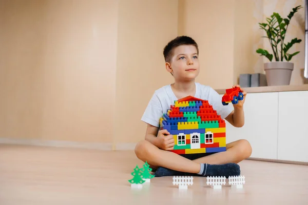 小さな男の子が建設キットで遊んで 家族全員のための大きな家を建てます 家庭の建設 — ストック写真