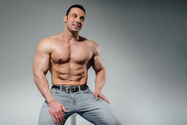 Young Athlete Jeans Poses Sitting Studio Sport — Stock Photo, Image