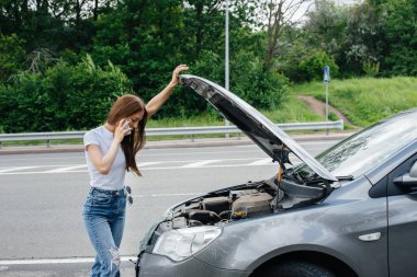Genç bir kız otoyolun ortasında bozuk bir arabanın yanında duruyor ve telefondan yardım istiyor. Aracın bozulması ve arızası. Yardım bekliyorum..