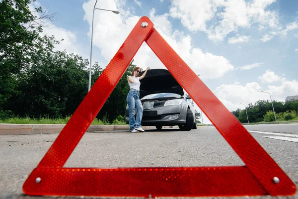 Genç bir kız otoyolun ortasında bozuk bir arabanın yanında duruyor ve telefondan yardım istiyor. Aracın bozulması ve arızası. Yardım bekliyorum..