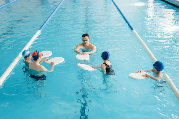 Grupa Chłopców Dziewcząt Trenuje Uczy Się Pływać Basenie Instruktorem Rozwój — Zdjęcie stockowe