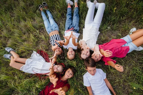 Grupo Crianças Felizes Está Deitado Grama Forma Círculo Sorrindo Alegremente — Fotografia de Stock