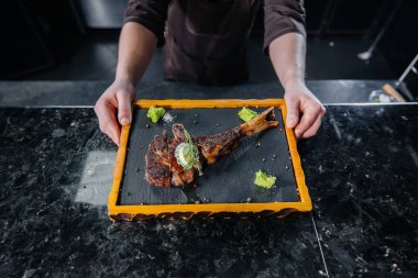 Profesyonel bir şef lezzetli bir ızgara biftek servis eder tereyağı ve baharatla. Restoranda ızgara et..