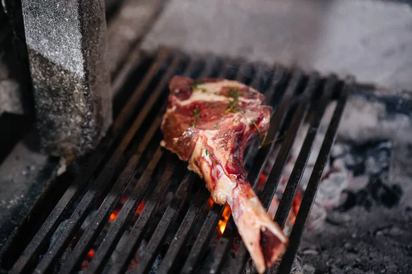 Juicy steak is grilled in a restaurant. Roasting meat in the fire on the grill.