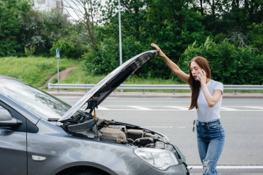 Genç bir kız otoyolun ortasında bozuk bir arabanın yanında duruyor ve telefondan yardım istiyor. Aracın bozulması ve arızası. Yardım bekliyorum..