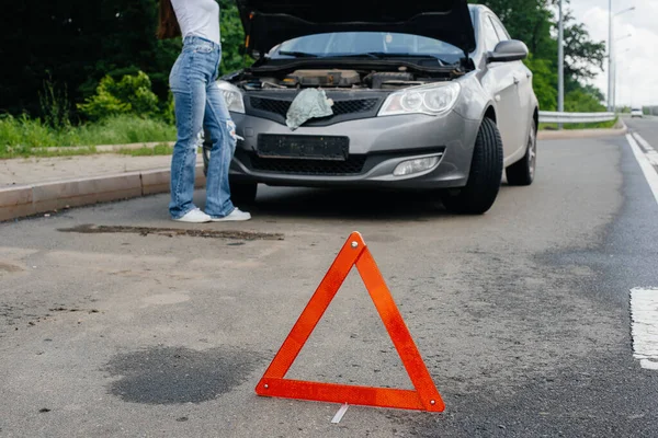 Una Joven Para Cerca Coche Averiado Medio Carretera Mira Debajo — Foto de Stock