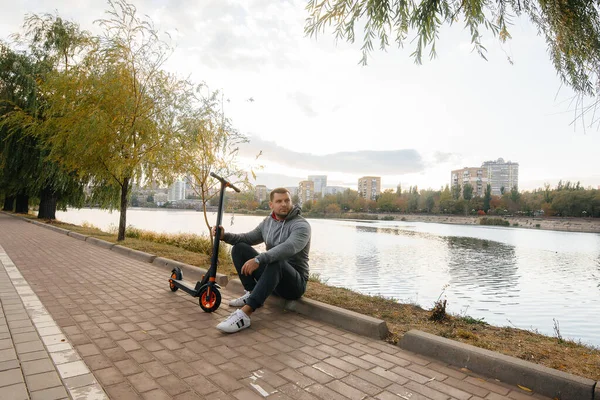 Een Jongeman Rijdt Het Park Een Elektrische Scooter Een Warme — Stockfoto