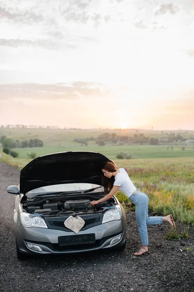 Una Joven Para Cerca Coche Roto Medio Carretera Durante Atardecer — Foto de Stock