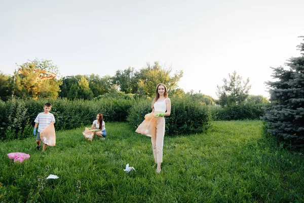 日没時に子供を持つ女の子のグループが公園内のゴミ収集に従事しています 環境への配慮 リサイクル — ストック写真
