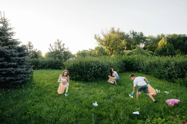 日没時に子供を持つ女の子のグループが公園内のゴミ収集に従事しています 環境への配慮 リサイクル — ストック写真