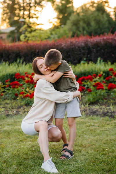 Uma Jovem Bela Mãe Beija Abraça Seu Filhinho Durante Pôr — Fotografia de Stock