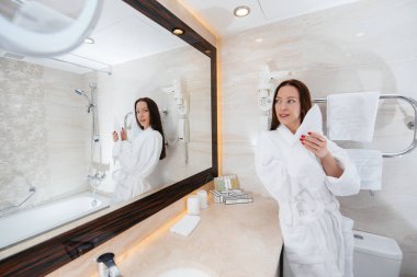 Beyaz bir banyoda genç ve güzel bir kız. Otelde taze günaydın..