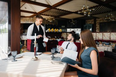 Şık bir garson, bir gurme restoranında randevuya gelen genç bir çifte servis yapar. Yemek şirketinde müşteri hizmetleri..
