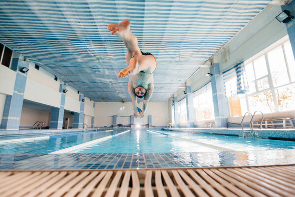 A young athlete trains and prepares for swimming competitions in the pool. Healthy lifestyle.