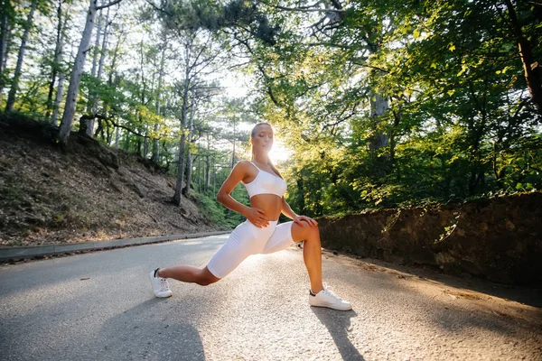Young Beautiful Girl Makes Lunges Warm Running Training Road Dense — Stock Photo, Image