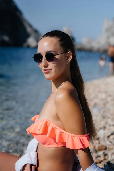 Piękna Młoda Kobieta Okularach Bikini Siedzi Brzegu Oceanu Tle Ogromnych — Zdjęcie stockowe