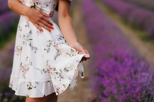 繊細なドレスと帽子の若い美しい女の子はラベンダーの美しいフィールドを歩き 花の香りを楽しんでいます 休暇と美しい自然 — ストック写真