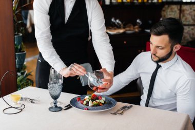 Garson, restorandaki masada nefis bir porsiyon deniz ürünleri salatası, ton balığı ve siyah havyar yapıyor. Yakından haute mutfağının nefis lezzetleri..
