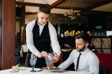 Garson, restorandaki masada nefis bir porsiyon deniz ürünleri salatası, ton balığı ve siyah havyar yapıyor. Yakından haute mutfağının nefis lezzetleri..