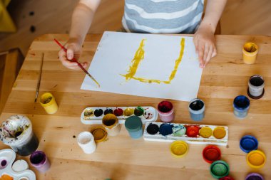 Odasında küçük sevimli bir çocuk oynuyor ve resim yapıyor. Eğlence ve eğlence. Evde kal.