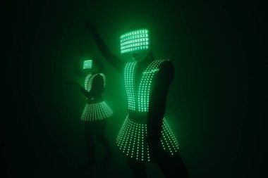 UV kostümlü iki seksi disko dansçısı. Partiler ve danslar.
