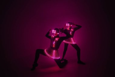 UV kostümlü iki seksi disko dansçısı. Partiler ve danslar.