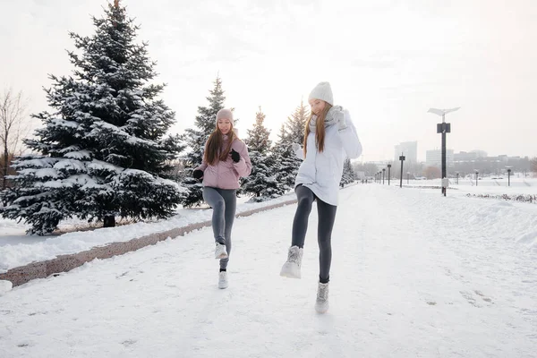 Dwie Młode Atletyczne Dziewczyny Biegające Parku Słoneczny Zimowy Dzień Zdrowy — Zdjęcie stockowe