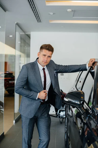 Joven Hombre Negocios Mira Coche Nuevo Concesionario Automóviles Comprar Coche —  Fotos de Stock