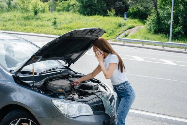 Genç bir kız otoyolun ortasında bozuk bir arabanın yanında duruyor ve telefondan yardım istiyor. Aracın bozulması ve arızası. Yardım bekliyorum..