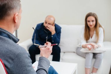 Genç evli bir çift terapi seansında bir psikologla konuşuyor. Psikoloji.