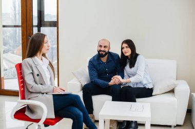 Genç, mutlu, evli bir çift terapi seansında bir psikologla konuşuyor. Psikoloji.