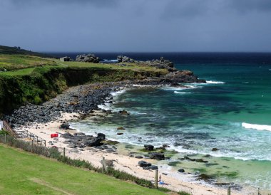 St. Ives Cornwall İngiltere 'nin vahşi Atlantik kıyısında turkuaz suyla dolu, güneşli bir yaz gününde gökyüzünde birkaç bulut olan taşralı Porthmeor Plajı
