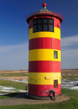 Meşhur Kırmızı Sarı Pilsum Deniz Feneri Açık mavi gökyüzü ile güneşli bir kış günü Doğu Frizya 'da