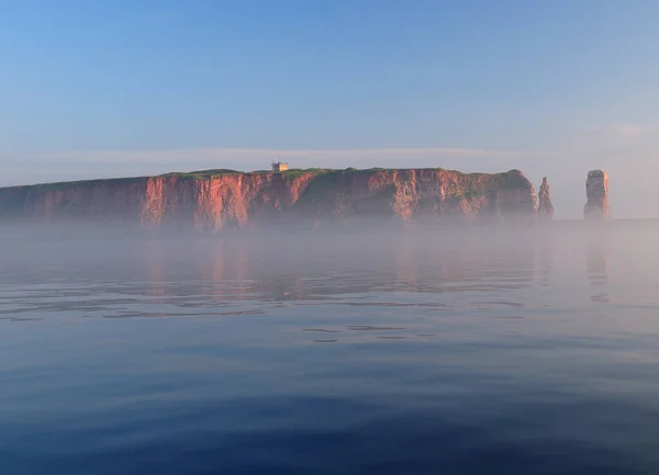霧の海からラスティな崖や北海の島ヘルゴランドの有名なシースタックランゲアンナへの眺め澄んだ青い空の晴れた夏の日 — ストック写真