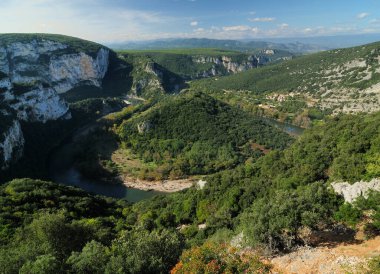 Mavi gökyüzünde birkaç bulutla güzel bir sonbahar gününde Fransa 'da Ardeche Nehri' nin sarmaladığı vadideki De L 'Ardeche Kanyonu' na hava görüntüsü