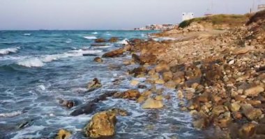 Dalgaların yukarıdan görünüşü mavi bir okyanusta kayalara çarpıyor. Deniz dalgaları güzel sahil manzaralı hava aracı 4K 'da. Kuş bakışı okyanus dalgalarının yukarıdan kayalıklara çarpması.