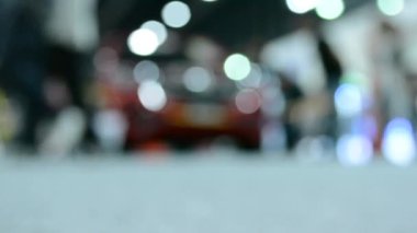 Bokeh Işığı 'nda yürüyen isimsiz kişilerin zemin seviyesindeki video görüntülerinin odak noktasından çıkarılmış.