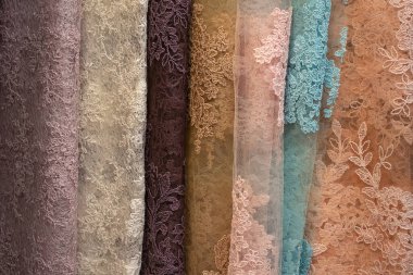 Renkli dantel kumaşlar işaretle satılmak üzere düzgünce dizilmiş.