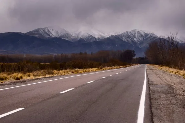 トゥプンガト メンドーサ アルゼンチンの雪のアンデス山脈へのアスファルト道路 — ストック写真